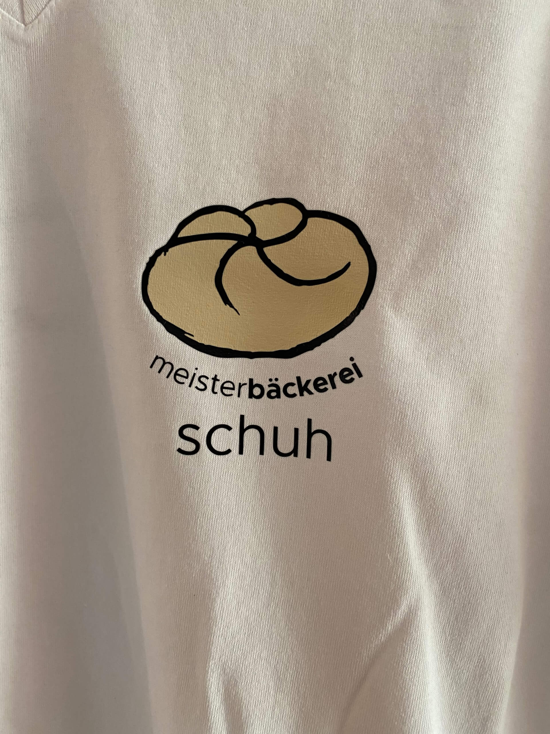 Logo der Meisterbäckerei Schuh auf einem weißen Hintergrund mit stilisiertem Brot.
