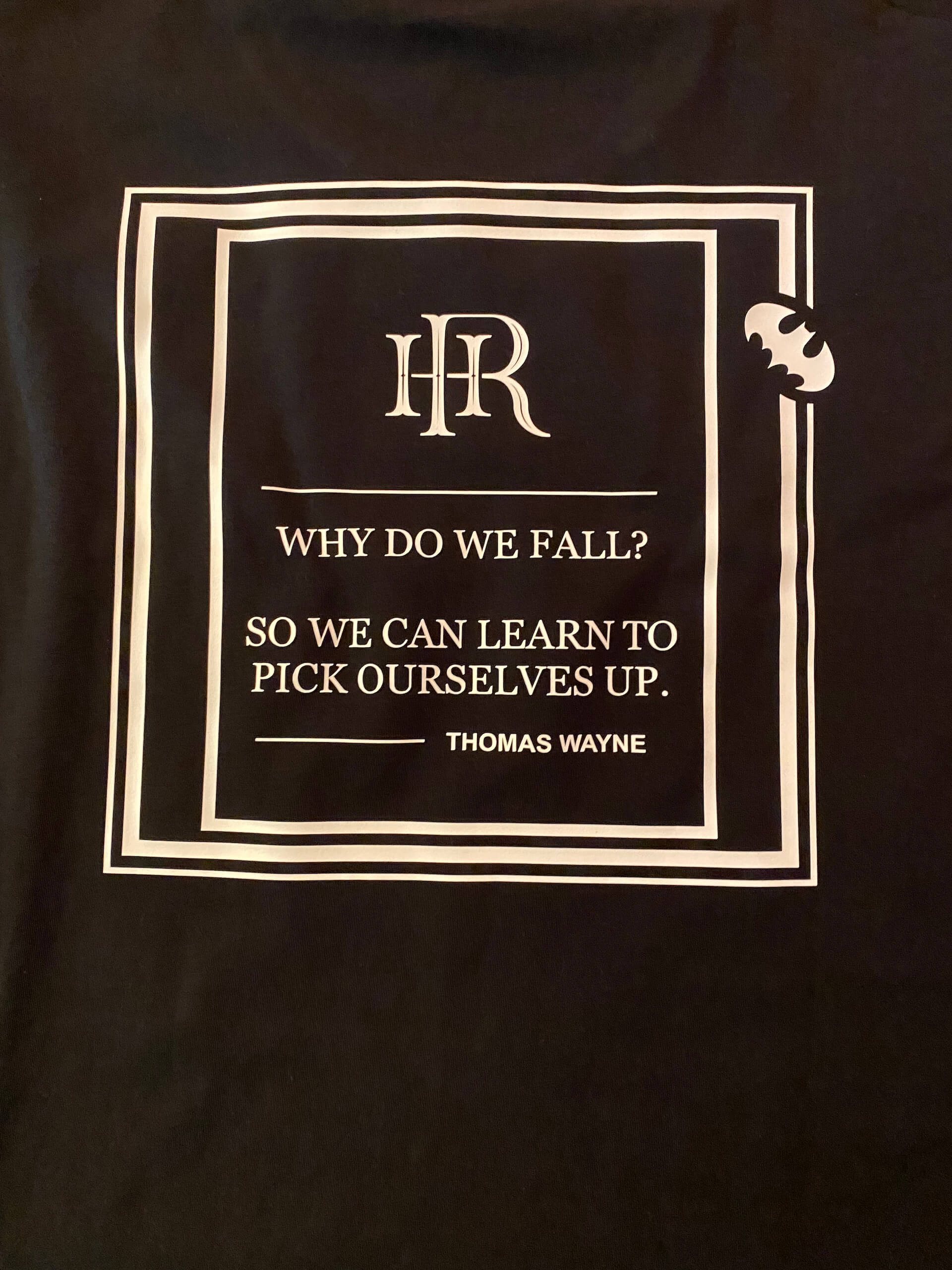 Schwarzes T-Shirt-Design mit Zitat von Thomas Wayne: Why do we fall? So we can learn to pick ourselves up.