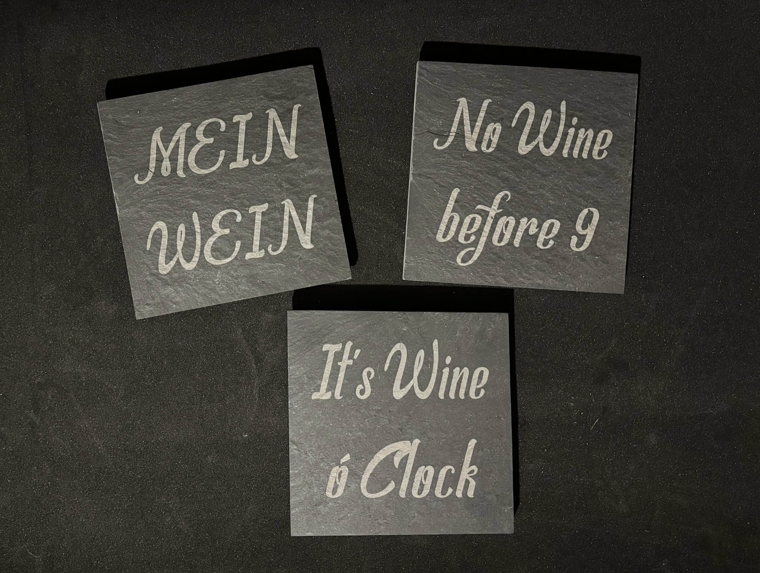 Schieferuntersetzer mit humorvollen Weinsprüchen: Mein Wein, No Wine before 9, It's Wine o'Clock.