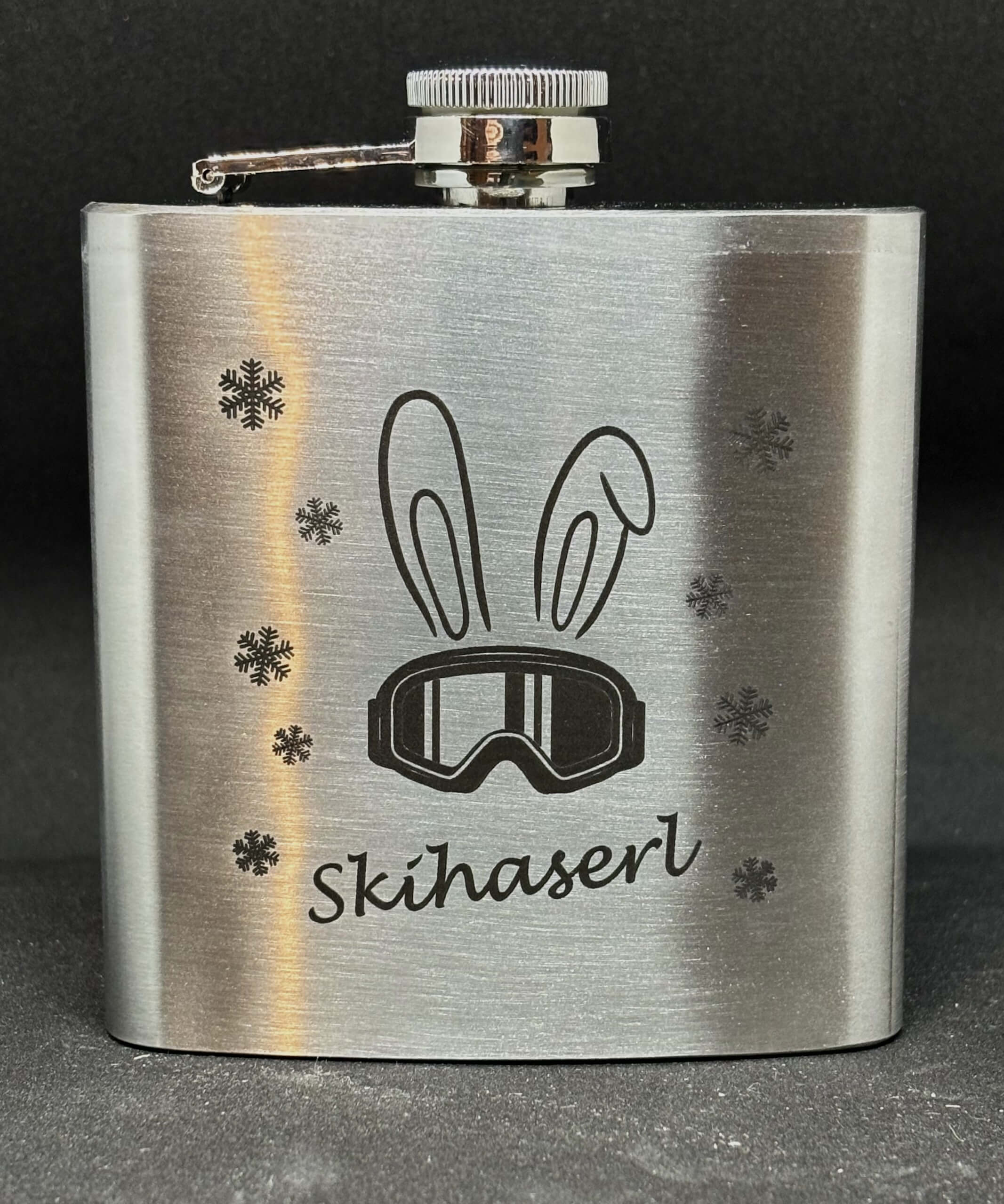 Flachmann mit Skihaserl-Design und Schneeflocken. Perfektes Accessoire für Skifreunde und Outdoor-Abenteuer.