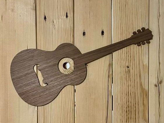 Holzgitarre im abstrakten Design auf Holzhintergrund – kreative Wanddekoration für Musikliebhaber.