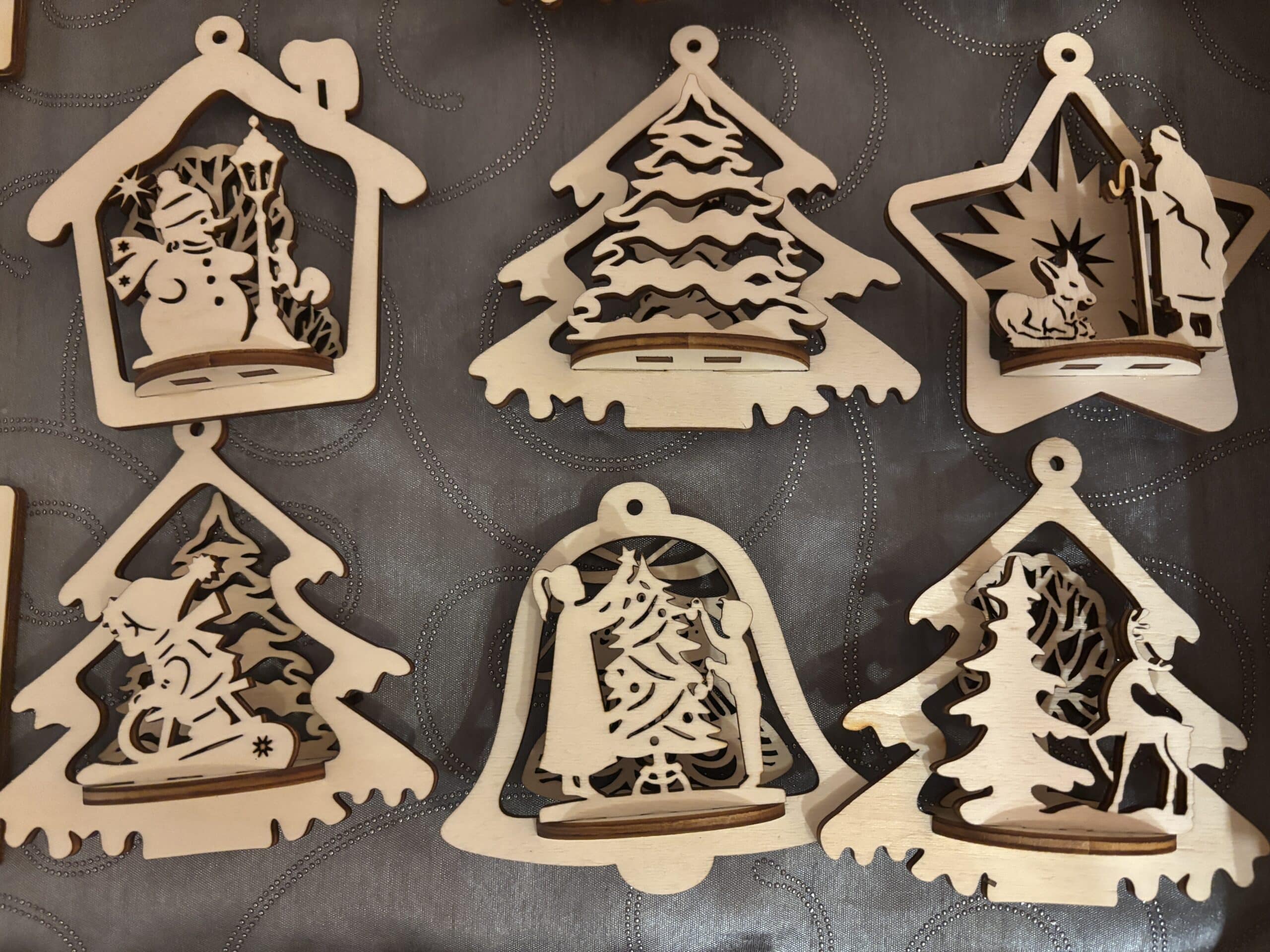 Holzornamente mit Schneemann, Weihnachtsbaum und Tieren, ideal für personalisierte Weihnachtsgeschenke von JMCP Lasergravuren.