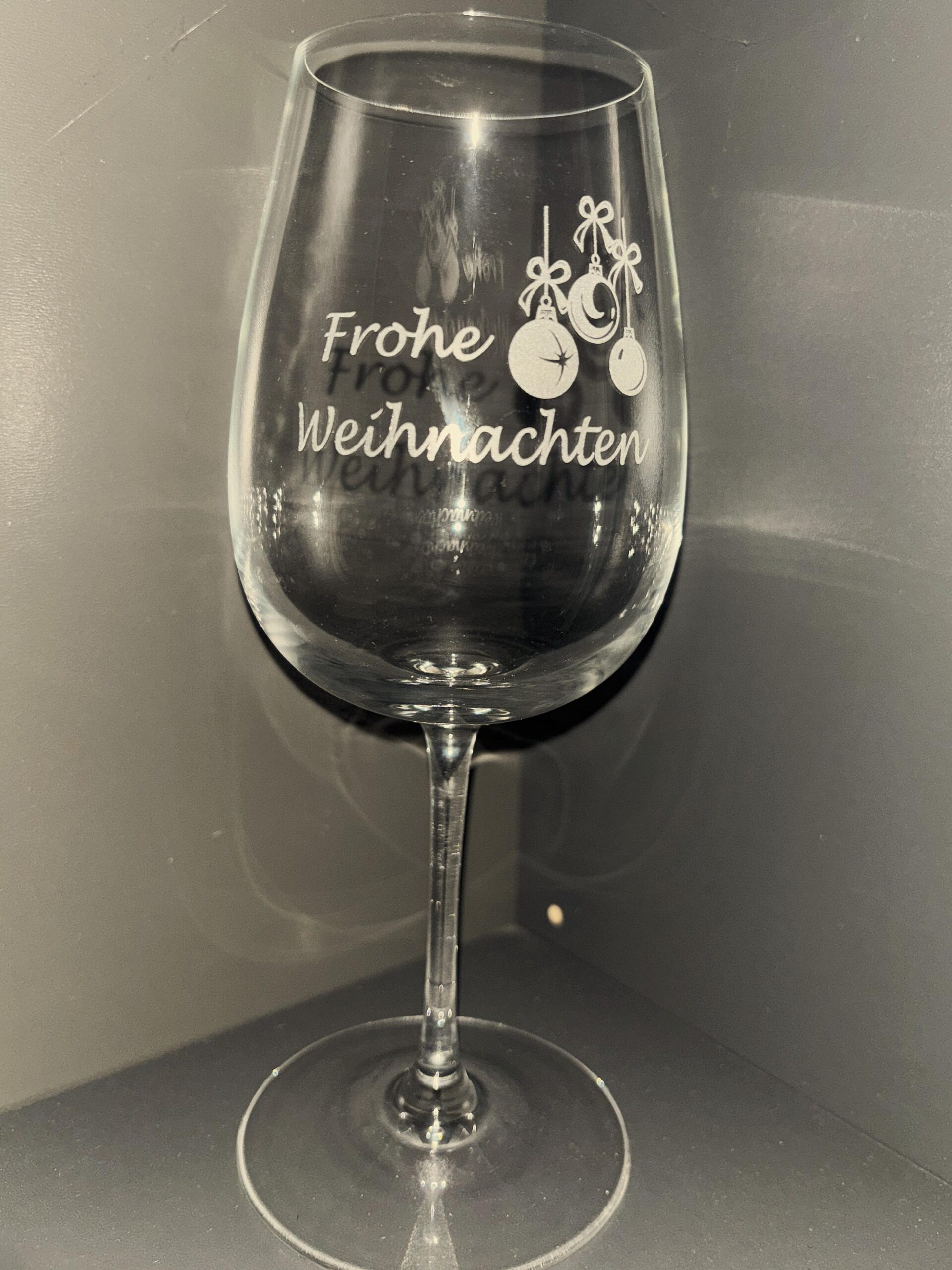 Weinglas mit eingraviertem „Frohe Weihnachten“ und Weihnachtsmotiven, ideal als personalisiertes Geschenk.