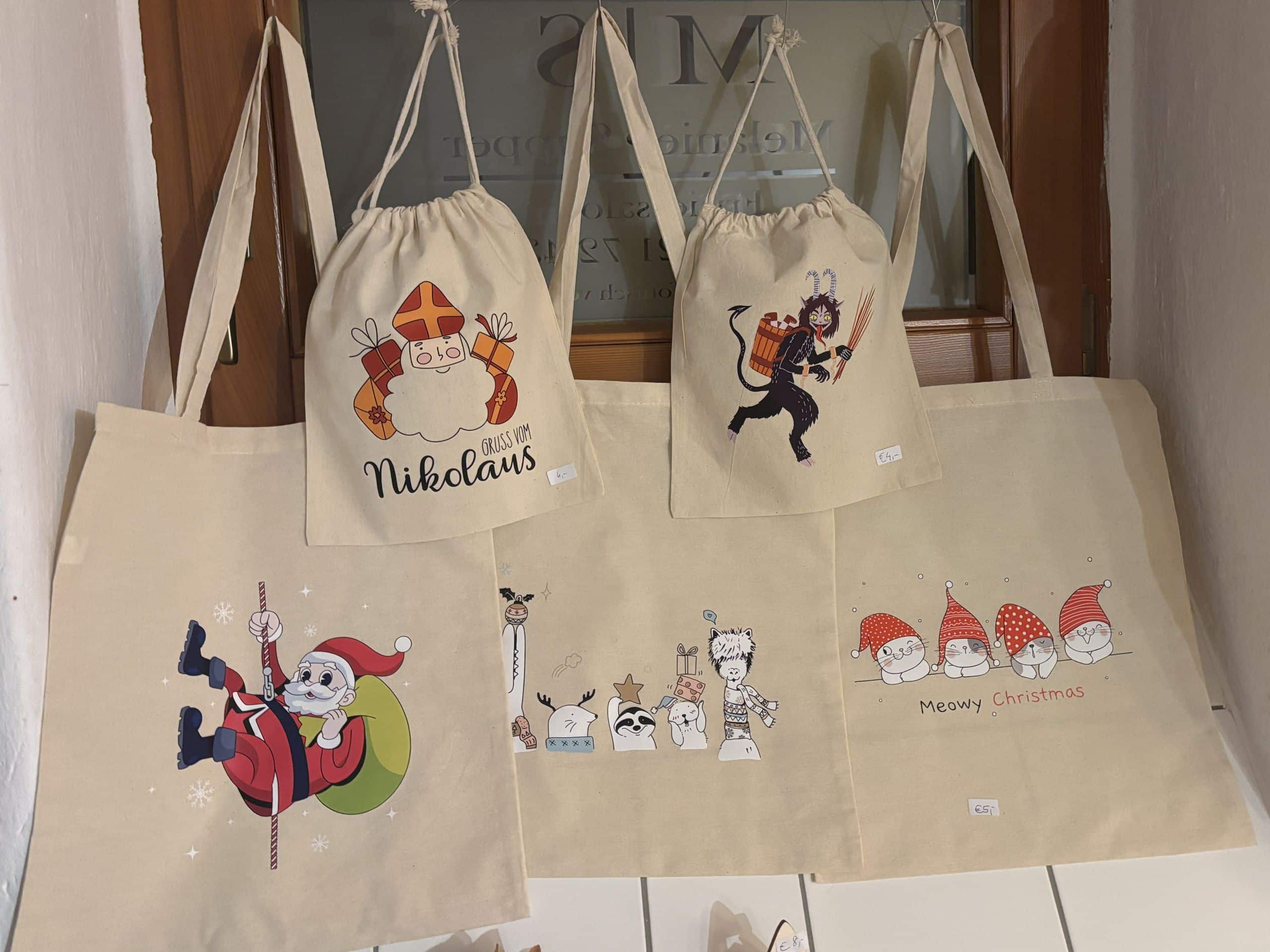 Weihnachtliche Stofftaschen mit Nikolaus- und Krampusmotiven, ideal als personalisierte Geschenke bei JMCP Lasergravuren.